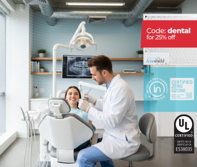 Handsome dentist working on a young patient in a bright, clean dental office—promoting air purification and safety.